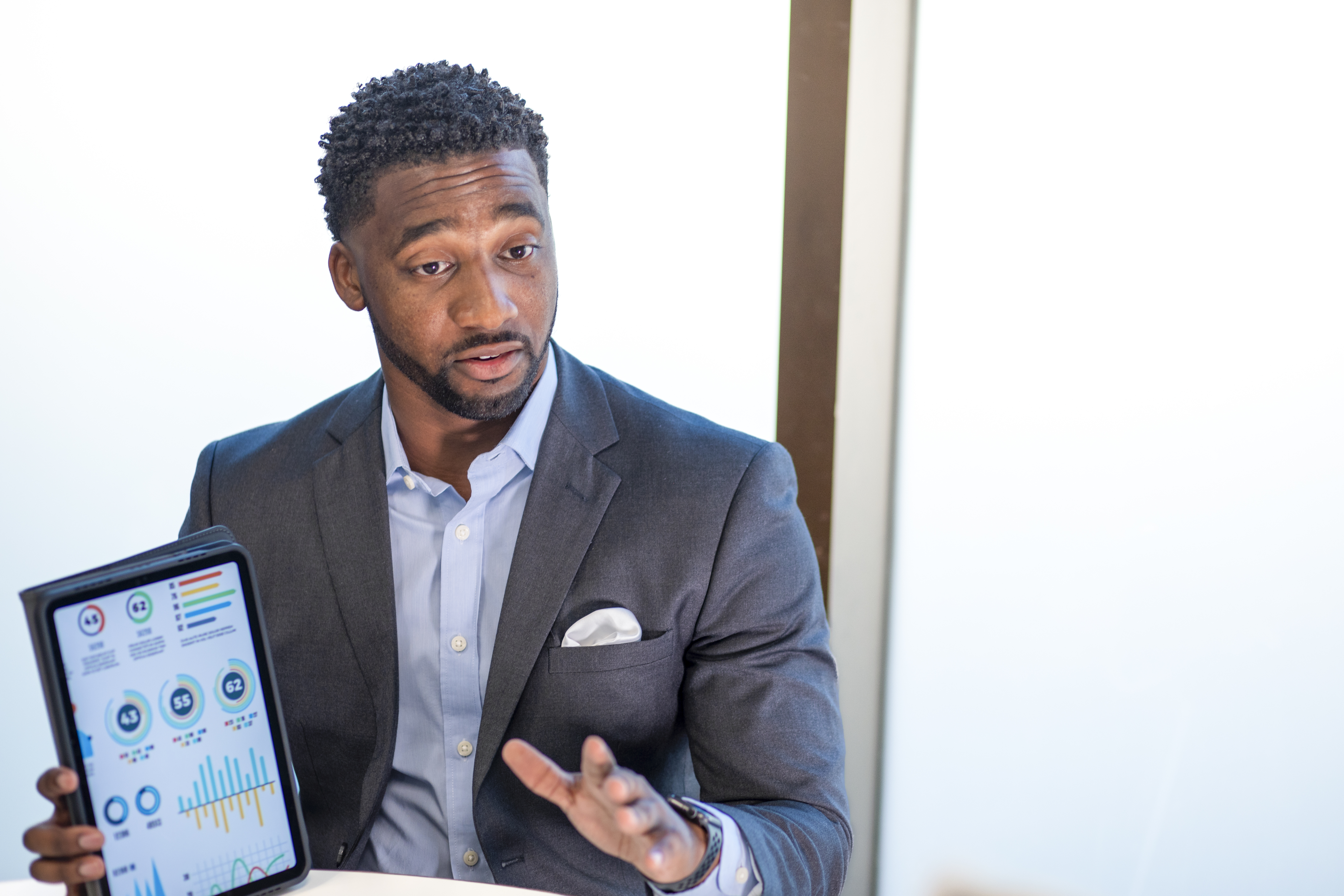 Ryan Owens presents data on a tablet. Owens earned his MBA degree online from UL Lafayette.