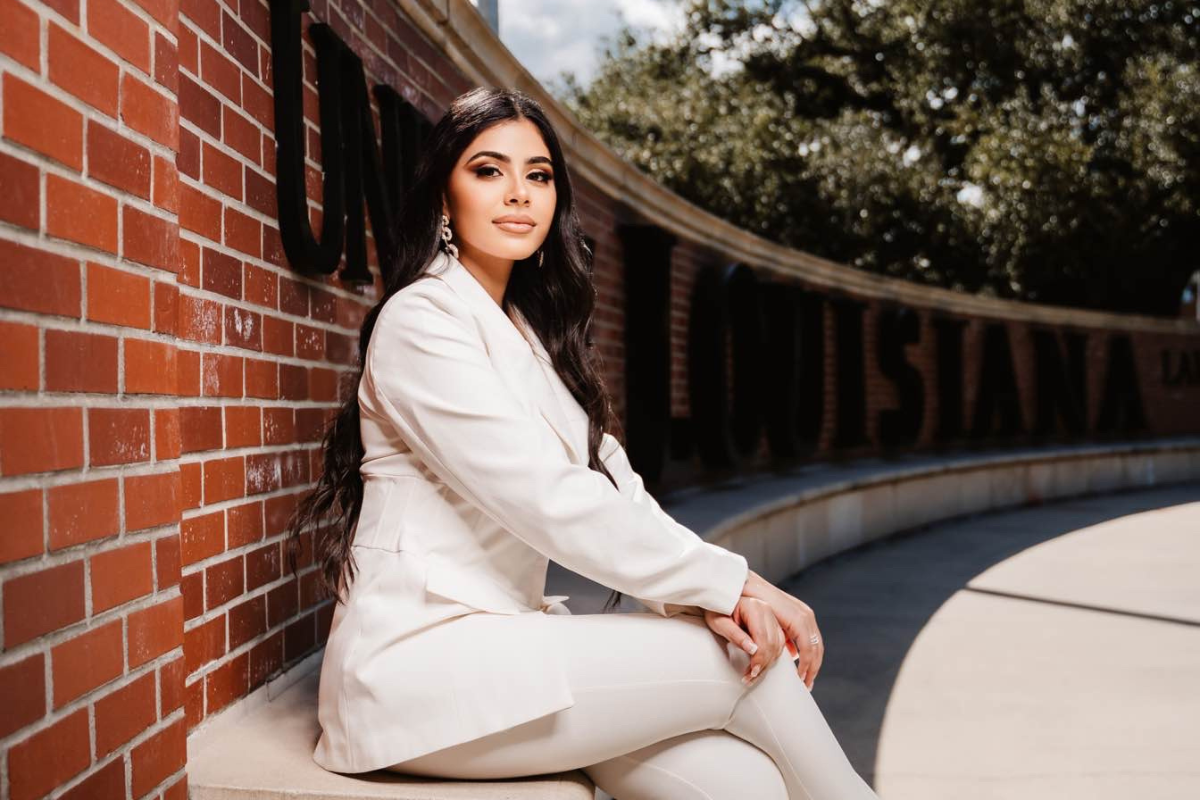 Tala Tobeh sits in front of the UL Lafayette wall. A graduate of UL Lafayette’s criminal justice online program, she now works with the state's fusion office.
